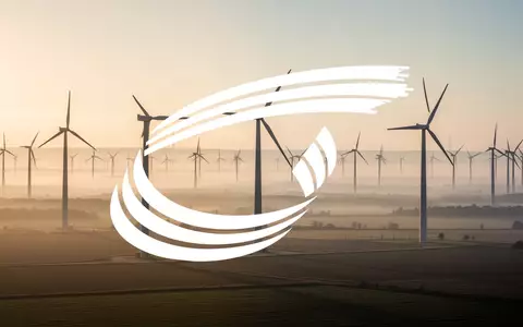 Moderne Windkraftanlagen in einer weiten, nebligen Landschaft bei Sonnenaufgang. - Foto: über boerse-global.de