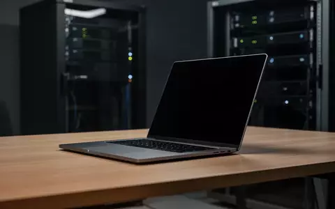 Ein moderner, dunkler Arbeitsplatz mit einem Laptop, dessen Bildschirm ausgeschaltet ist, in einem minimalistischen Büro. - Foto: über boerse-global.de