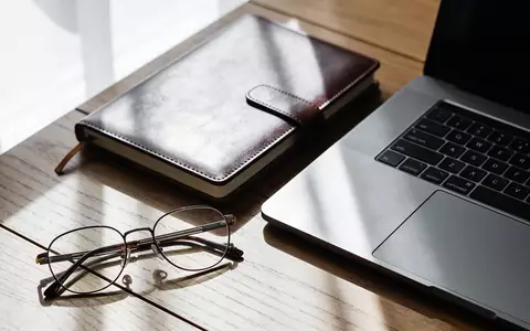 Ein professioneller Schreibtisch mit Laptop und Notizbuch in einer hellen, natĂŒrlichen Arbeitsumgebung. - Foto: ĂŒber boerse-global.de