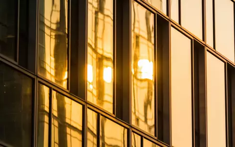 Moderne Glasfassade eines Bürogebäudes in einem Finanzviertel bei Sonnenuntergang. - Foto: über boerse-global.de