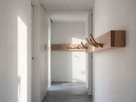 Minimalistischer, schmaler Flur mit einem modernen Wandpaneel aus Holz in heller Eichenoptik bei natürlichem Tageslicht. - Foto: über boerse-global.de