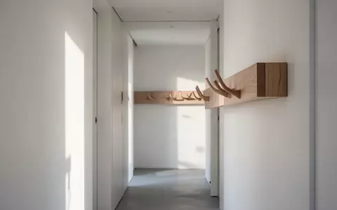 Minimalistischer, schmaler Flur mit einem modernen Wandpaneel aus Holz in heller Eichenoptik bei natürlichem Tageslicht. - Foto: über boerse-global.de