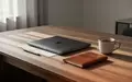 Ein minimalistischer Schreibtisch mit einem geschlossenen Laptop und einem Notizbuch in einem hellen, modernen Raum. - Foto: über boerse-global.de