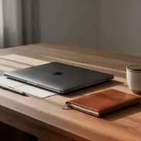 Ein minimalistischer Schreibtisch mit einem geschlossenen Laptop und einem Notizbuch in einem hellen, modernen Raum. - Foto: über boerse-global.de