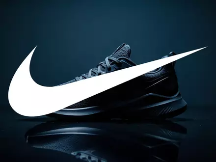 Ein minimalistischer Sportschuh auf einer dunklen, reflektierenden Oberfläche in einer stimmungsvollen, düsteren Umgebung. - Foto: über boerse-global.de