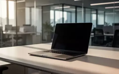 Ein moderner, aufgeräumter Arbeitsplatz mit einem Laptop mit dunklem Bildschirm in einem hellen Büro. - Foto: über boerse-global.de