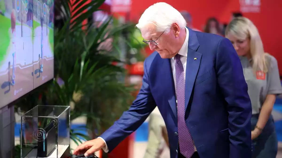 Steinmeier am Nintendo-Messestand, wo er digitales Bogenschießen als Sportart ausprobierte. - Bild: Christoph Reichwein/dpa