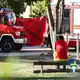 Ein Feuerwehrmann sitzt in der Nähe des Tatorts.  - Bild: Britta Pedersen/dpa