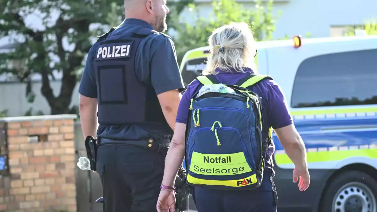 Mitarbeiter der Notfallseelsorge sind am Einsatzort.  - Bild: Britta Pedersen/dpa