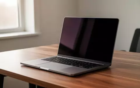 Ein moderner Laptop auf einem hölzernen Schreibtisch in einem hellen Büro, der Bildschirm ist dunkel. - Foto: über boerse-global.de
