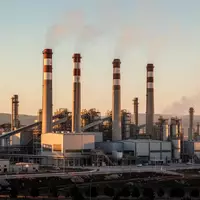 Moderne Industrieanlage mit hohen Schornsteinen vor einem klaren Himmel als Symbol für die neue Emissionshandelsverordnung. - Foto: über boerse-global.de