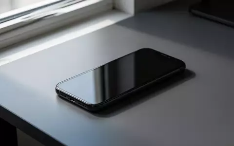 Ein minimalistisches Smartphone mit dunklem Design liegt auf einer matten, grauen Schreibtischoberfläche. - Foto: über boerse-global.de