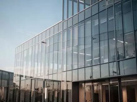 Modernes Glasgebäude bei Tageslicht, das die fortschreitende Digitalisierung im Finanzsektor symbolisiert. - Foto: über boerse-global.de