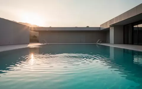 Ein leeres, modernes Außenbecken mit klarem, türkisblauem Wasser im sanften Morgenlicht. - Foto: über boerse-global.de
