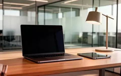 Ein minimalistischer Arbeitsplatz mit einem Laptop mit ausgeschaltetem Bildschirm und einer Schreibtischlampe. - Foto: über boerse-global.de