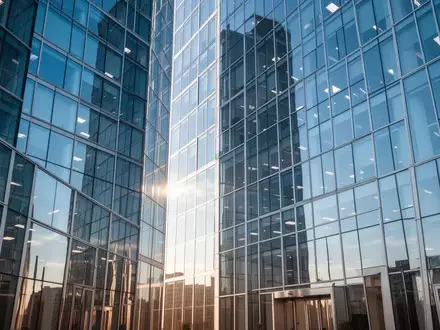 Moderne Glasfassade eines Bürogebäudes bei hellem Tageslicht als Symbol für Stabilität und Finanzmärkte. - Foto: über boerse-global.de