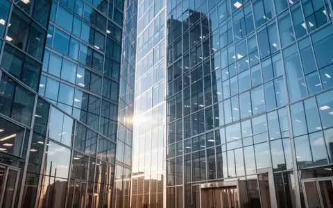 Moderne Glasfassade eines Bürogebäudes bei hellem Tageslicht als Symbol für Stabilität und Finanzmärkte. - Foto: über boerse-global.de