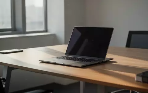 Ein geschlossener Laptop auf einem minimalistischen Schreibtisch in einer modernen Büroumgebung. - Foto: über boerse-global.de