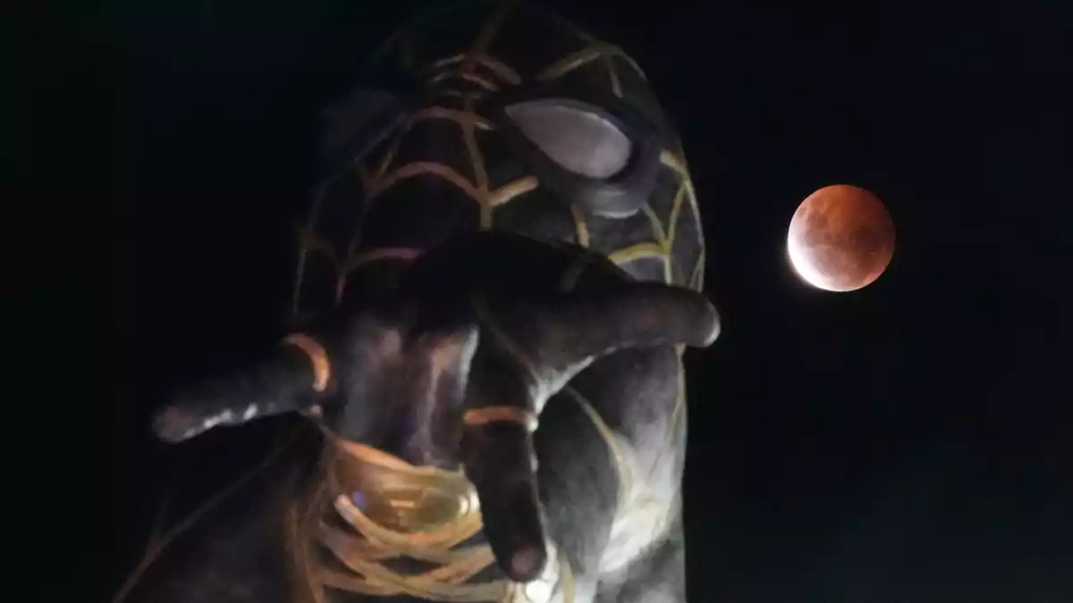 Während der partiellen Mondfinsternis geht in El Alto, Bolivien, der Mond hinter einer Spider-Man-Statue auf. - Bild: Juan Karita/AP/dpa