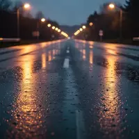 Leere, regennasse Asphaltstraße bei Dämmerung mit atmosphärischer Straßenbeleuchtung im Hintergrund. - Foto: über boerse-global.de