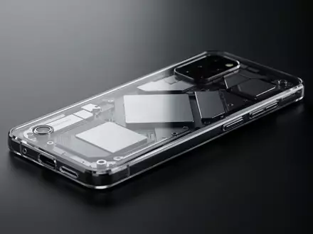 Ein minimalistisches Smartphone mit transparentem Gehäuse liegt auf einer dunklen Oberfläche. - Foto: über boerse-global.de
