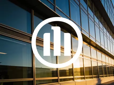 Moderne Glasfassade eines Bürogebäudes bei Sonnenuntergang als Symbol für finanzielle Stabilität und Vertrauen - Foto: über boerse-global.de