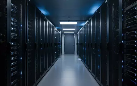 Dunkler Serverraum mit beleuchteten Serverschränken in einem modernen Rechenzentrum. - Foto: über boerse-global.de