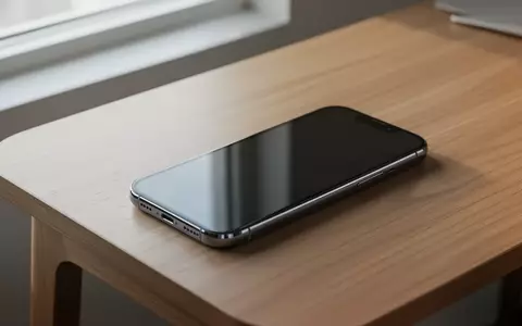 Ein modernes Smartphone liegt auf einem minimalistischen Schreibtisch, der Bildschirm ist dunkel und spiegelt das Tageslicht. - Foto: über boerse-global.de