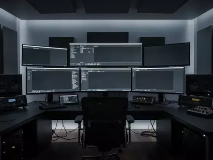 Ein minimalistisches, professionelles Schnittstudio mit dunklen Monitoren und moderner technischer Ausstattung. - Foto: über boerse-global.de