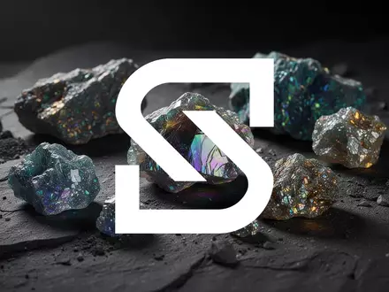 Nahaufnahme von glänzenden Seltenerdmineralien auf einem dunklen, texturierten Untergrund in professioneller Beleuchtung. - Foto: über boerse-global.de