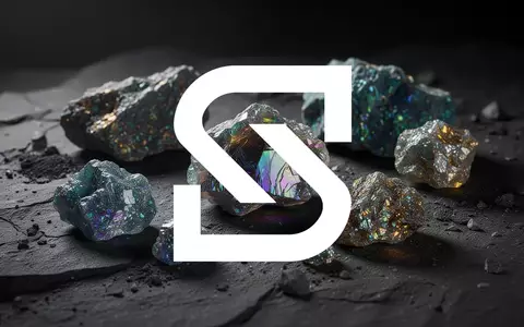 Nahaufnahme von glänzenden Seltenerdmineralien auf einem dunklen, texturierten Untergrund in professioneller Beleuchtung. - Foto: über boerse-global.de