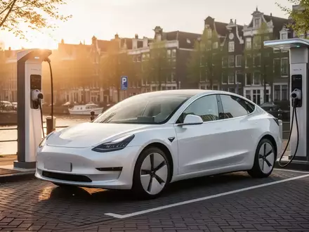 Ein weißes Elektroauto steht an einer modernen Ladestation in einer niederländischen Stadt bei Sonnenuntergang. - Foto: über boerse-global.de