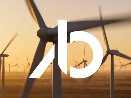 Moderne Windkraftanlagen in einer weiten Landschaft bei Sonnenuntergang als Symbol für erneuerbare Energien. - Foto: über boerse-global.de