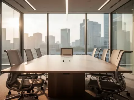 Ein leerer, modern gestalteter Konferenzraum mit einem großen Holztisch und ergonomischen Stühlen bei natürlichem Licht. - Foto: über boerse-global.de