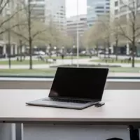 Ein minimalistischer, leerer Schreibtisch mit einem geschlossenen Laptop vor einem hellen Fenster mit Blick ins Grüne. - Foto: über boerse-global.de
