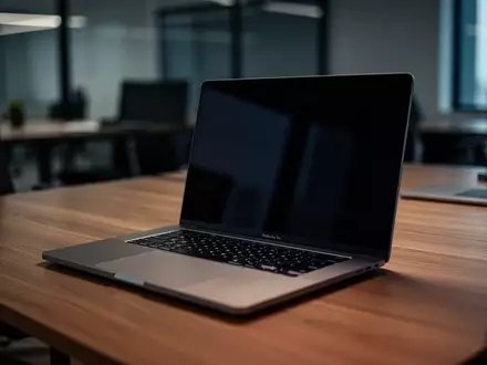 Ein moderner Laptop mit ausgeschaltetem Bildschirm auf einem Schreibtisch in einem professionellen Büroambiente. - Foto: über boerse-global.de