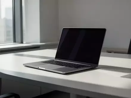 Ein moderner, minimalistischer Büroarbeitsplatz mit einem Laptop bei ausgeschaltetem Bildschirm in natürlichem Licht. - Foto: über boerse-global.de