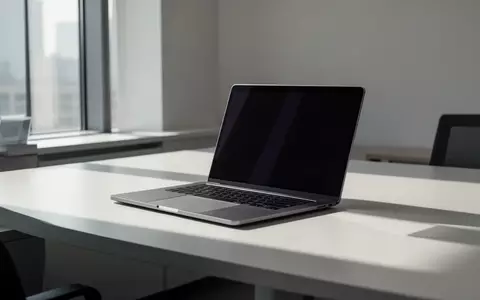 Ein moderner, minimalistischer Büroarbeitsplatz mit einem Laptop bei ausgeschaltetem Bildschirm in natürlichem Licht. - Foto: über boerse-global.de