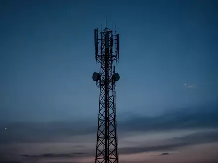 Ein Mobilfunkmast bei Dämmerung als Symbol für die Netzwerkinfrastruktur. - Foto: über boerse-global.de