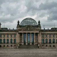 Die gläserne Kuppel des Reichstagsgebäudes in Berlin bei bewölktem Himmel. - Foto: über boerse-global.de