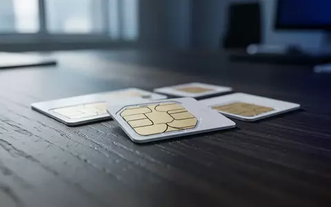 Mehrere leere SIM-Karten liegen auf einem dunklen Holztisch in einer professionellen Büroumgebung. - Foto: über boerse-global.de