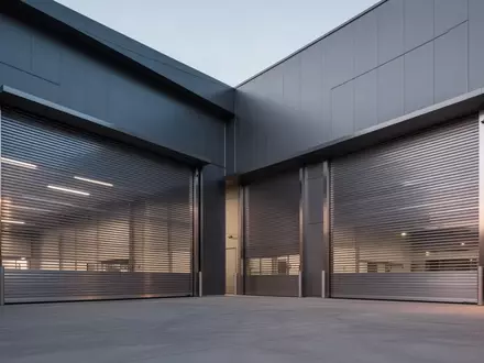 Geschlossene Industrietore eines modernen Fabrikgebäudes in der Abenddämmerung. - Foto: über boerse-global.de