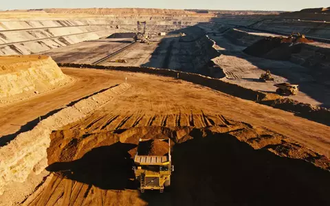 Ein weitläufiges Lithium-Bergwerk in der Abendsonne mit Baumaschinen vor einer bergigen Landschaft. - Foto: über boerse-global.de