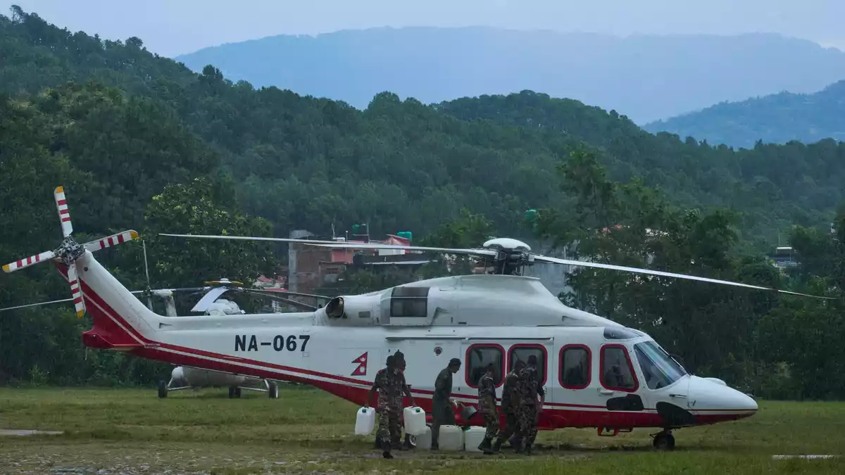 Soldaten der nepalesischen Armee betanken einen Hubschrauber, bevor dieser zu einem Rettungseinsatz nach den Sturzfluten abhebt. - Bild: Niranjan Shrestha/AP/dpa