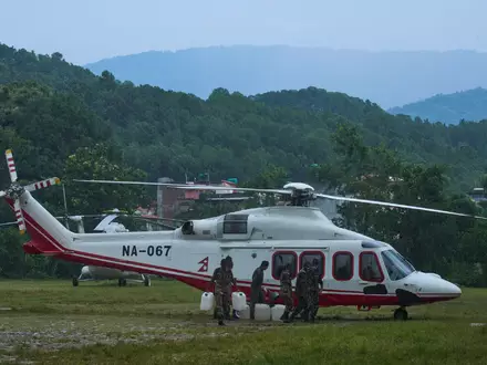 Soldaten der nepalesischen Armee betanken einen Hubschrauber, bevor dieser zu einem Rettungseinsatz nach den Sturzfluten abhebt. - Foto: Niranjan Shrestha/AP/dpa