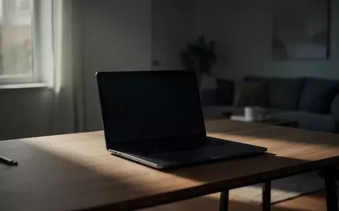 Ein unbenutzter Laptop auf einem Schreibtisch in einem ruhigen, schwach beleuchteten Raum. - Foto: über boerse-global.de