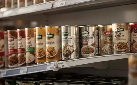 Mehrere Metallkonservendosen in einem Supermarktregal bei natürlichem Licht. - Foto: über boerse-global.de