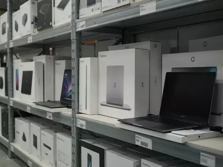 Ordentlich sortierte Regale in einem Logistikzentrum mit verpackten Elektronikartikeln und Laptops. - Foto: über boerse-global.de