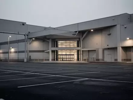 Ein verlassenes Baumarktgebäude mit großem, leerem Parkplatz in der Abenddämmerung. - Foto: über boerse-global.de