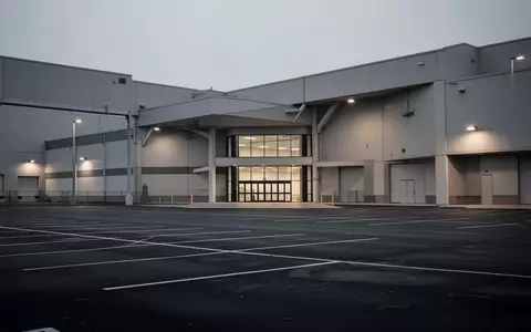 Ein verlassenes Baumarktgebäude mit großem, leerem Parkplatz in der Abenddämmerung. - Foto: über boerse-global.de